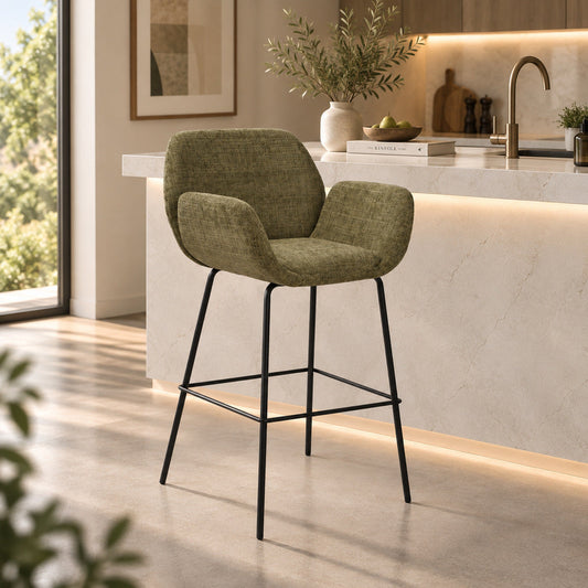 Gallery Everyday Arlo Bar Chair in Olive Moss, featuring rich green fabric upholstery, curved armrests, black metal legs and an integrated footrest.
