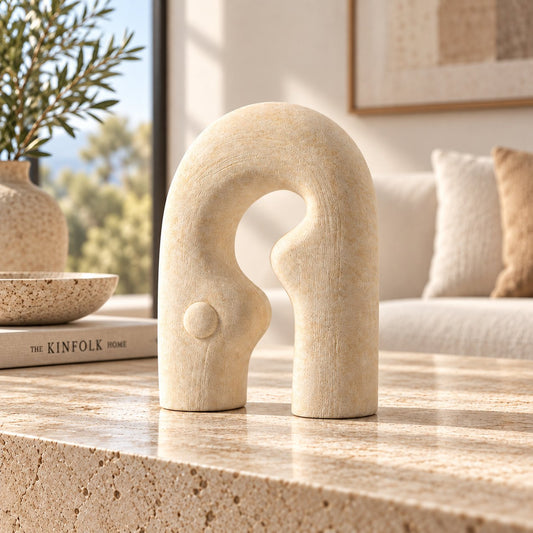 Gallery Everyday Matera Arch Ornament, featuring a textured cream abstract design on a marble coffee table.
