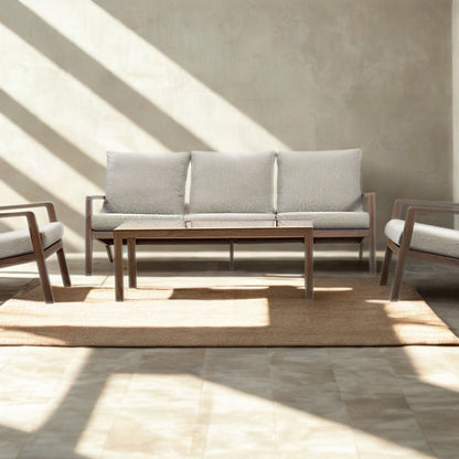Full Syracuse outdoor suite with sofa, two armchairs and timber coffee table on a jute rug in sunlight