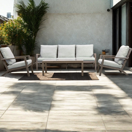 Weathered-wood outdoor lounge suite with grey cushions and a coffee table on a sunny tiled terrace