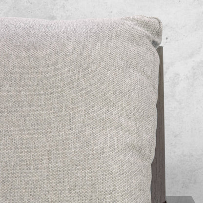 Detail of a soft light-grey woven outdoor cushion beside the Syracuse suite's grey timber frame