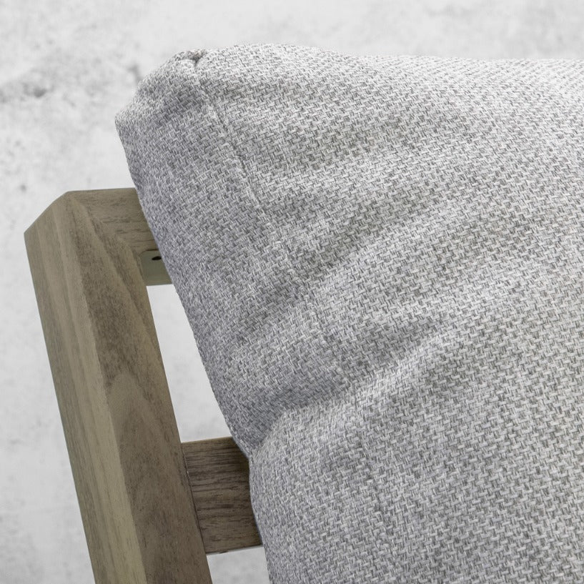 Grey woven cushion resting on the weathered timber armrest of the Syracuse outdoor lounge suite