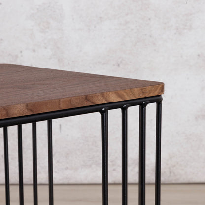 Close-up of the Gallery Everyday Camila Side Table in Walnut, showing the wood-grain tabletop corner and black metal slatted base.